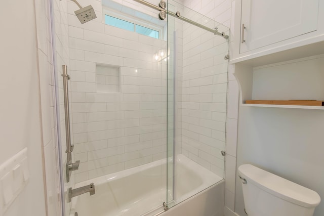 bathroom featuring toilet and bath / shower combo with glass door