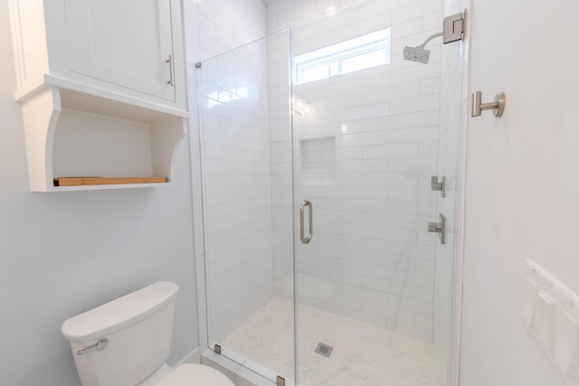 bathroom with toilet and a shower with door