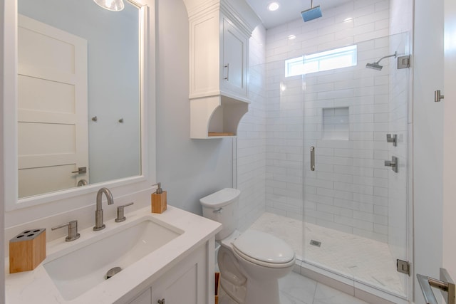 bathroom with vanity, toilet, and a shower with door