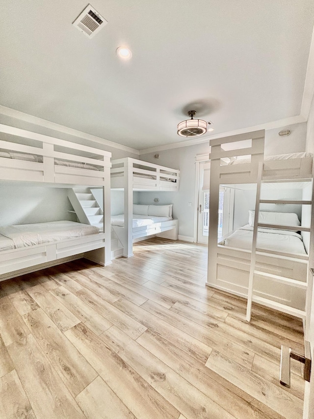 unfurnished bedroom with light wood-type flooring and crown molding