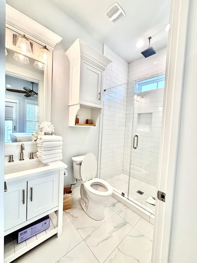 bathroom featuring ceiling fan, a shower with door, a healthy amount of sunlight, and toilet