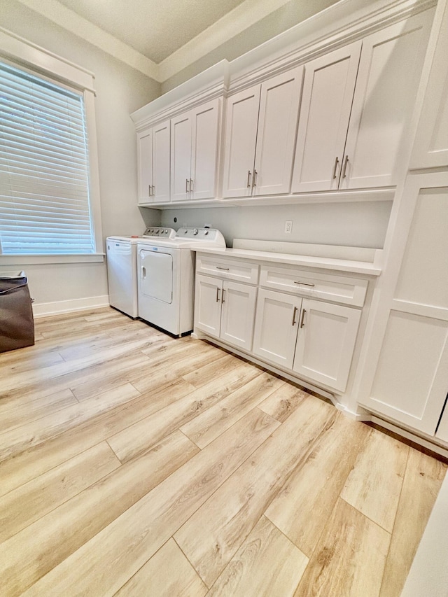 laundry room with cabinets, light hardwood / wood-style floors, washer and dryer, and ornamental molding