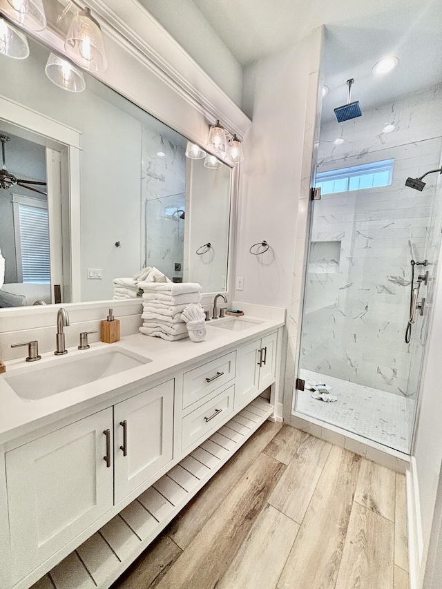 bathroom featuring a tile shower, vanity, and hardwood / wood-style flooring