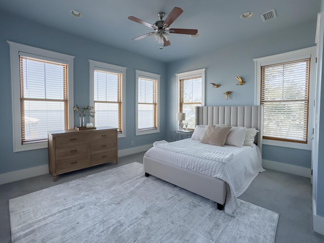 bedroom featuring multiple windows, light carpet, and ceiling fan