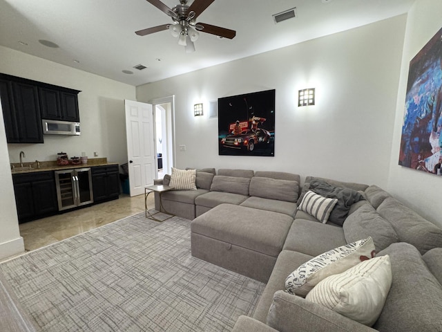 living room featuring wine cooler, ceiling fan, and indoor wet bar