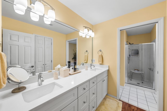 bathroom with hardwood / wood-style floors, vanity, and a shower with door