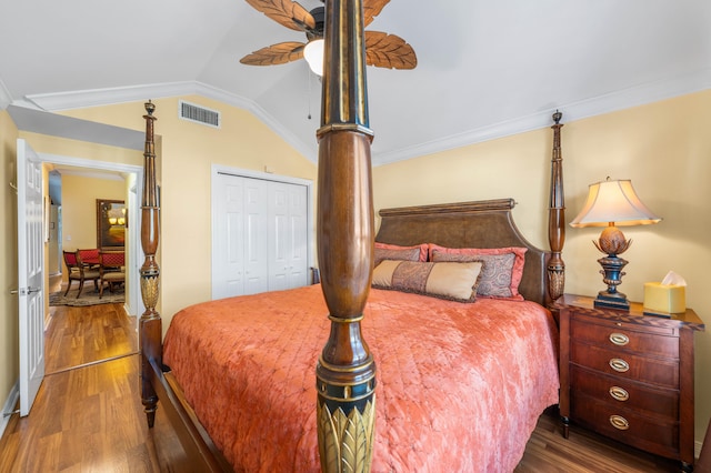 bedroom with a closet, ceiling fan, hardwood / wood-style floors, and vaulted ceiling