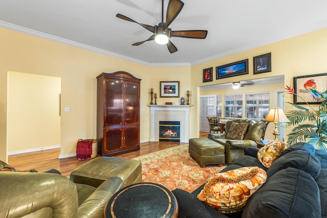 living room featuring a tiled fireplace, crown molding, and hardwood / wood-style flooring