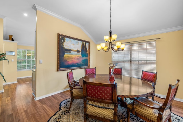 dining room with hardwood / wood-style floors, vaulted ceiling, crown molding, and an inviting chandelier