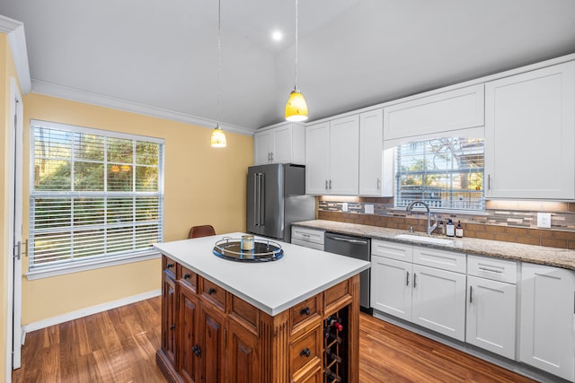 kitchen featuring white cabinets, decorative light fixtures, a wealth of natural light, and appliances with stainless steel finishes