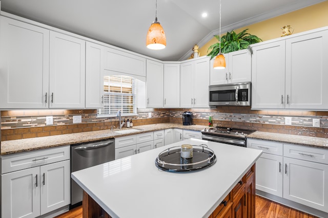 kitchen with sink, tasteful backsplash, decorative light fixtures, lofted ceiling, and appliances with stainless steel finishes