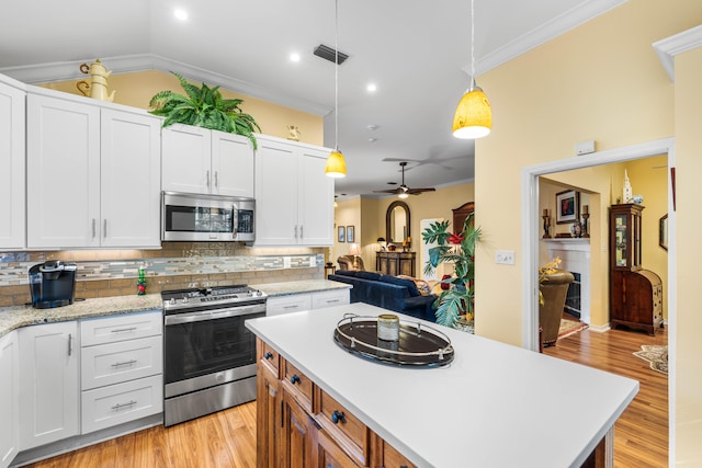 kitchen with white cabinets, ceiling fan, hanging light fixtures, and appliances with stainless steel finishes