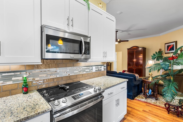 kitchen featuring white cabinets, appliances with stainless steel finishes, light hardwood / wood-style flooring, and crown molding