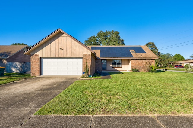 ranch-style house featuring a front lawn, a garage, and solar panels