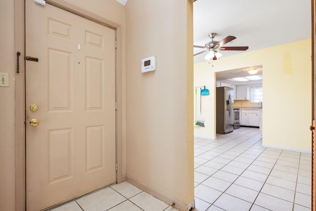 tiled entryway featuring ceiling fan