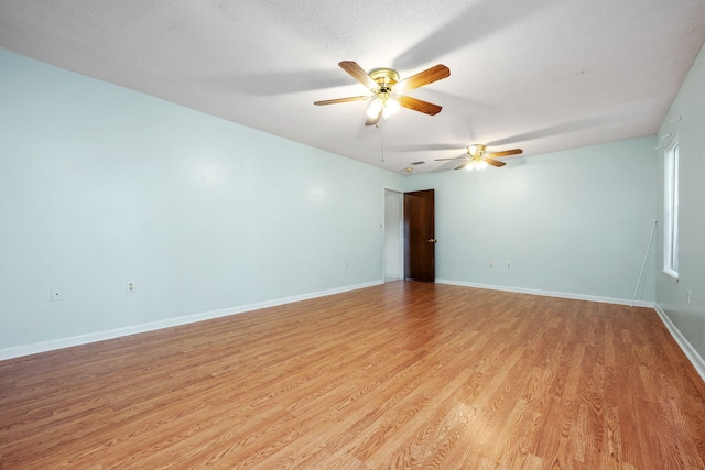 spare room with a textured ceiling, light wood-type flooring, and ceiling fan