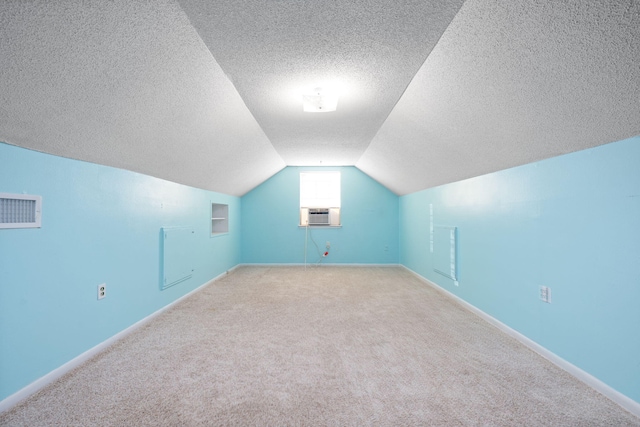 bonus room with light colored carpet, lofted ceiling, and a textured ceiling