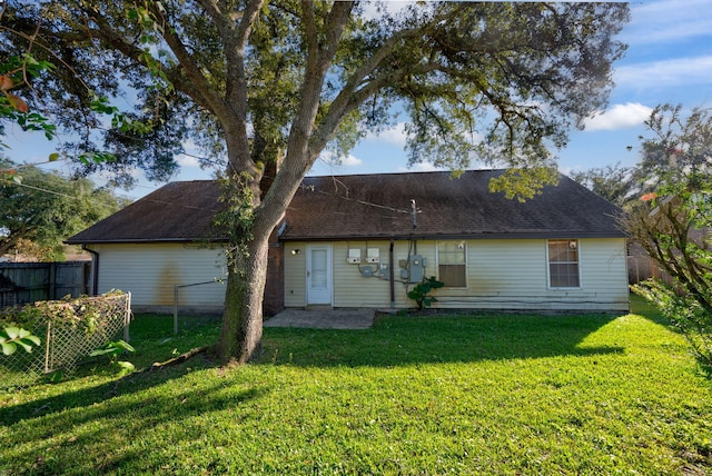 rear view of property featuring a lawn