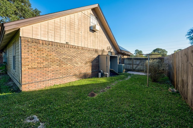 rear view of house featuring cooling unit and a yard