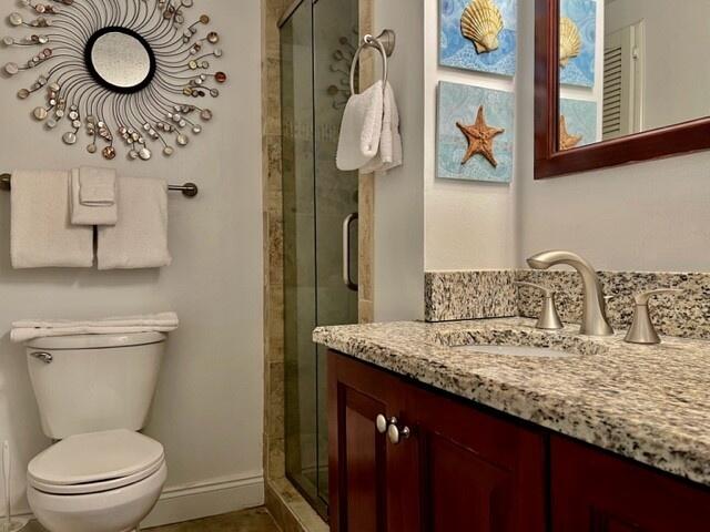 bathroom featuring toilet, vanity, and walk in shower