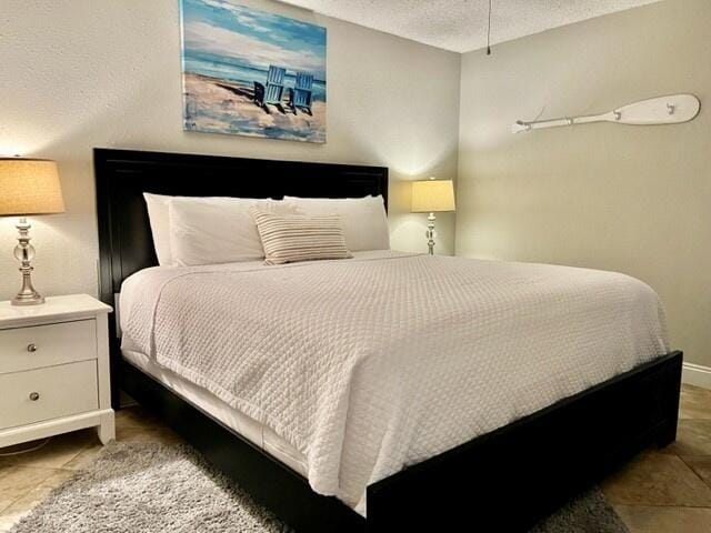 tiled bedroom featuring a textured ceiling