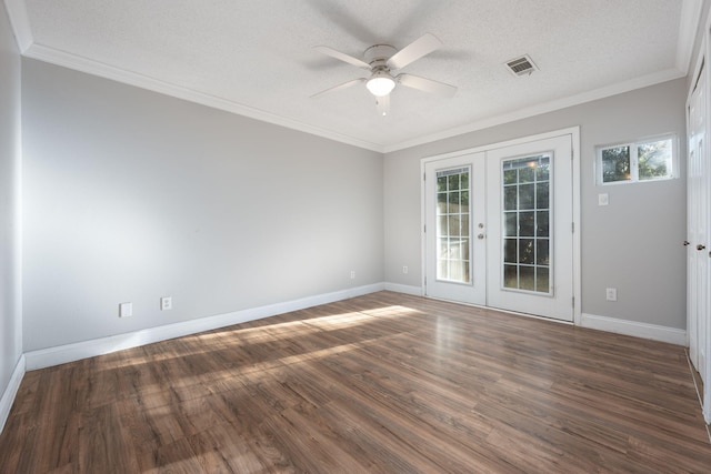 spare room with a textured ceiling, crown molding, french doors, and dark hardwood / wood-style floors