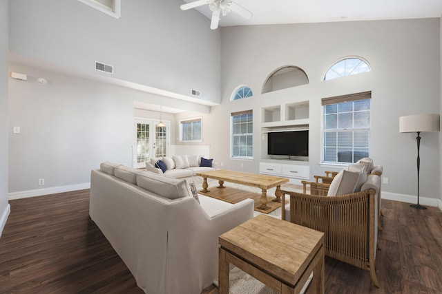 living room featuring a high ceiling, dark hardwood / wood-style flooring, and ceiling fan