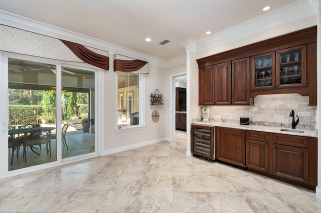 bar with tasteful backsplash, dark brown cabinetry, light stone countertops, and beverage cooler