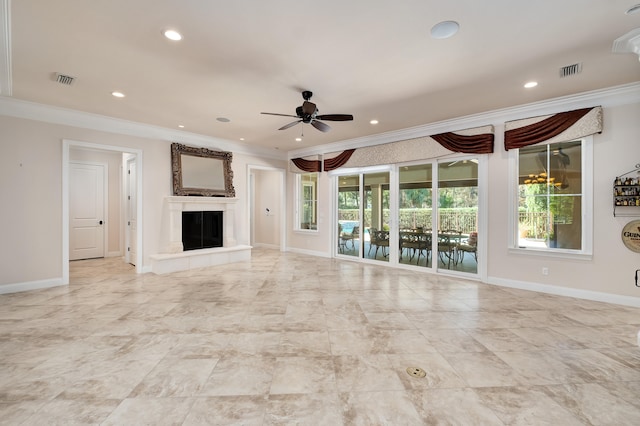 unfurnished living room featuring ceiling fan, plenty of natural light, and ornamental molding