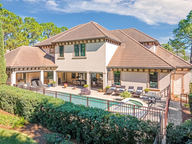 rear view of property featuring a fenced in pool and a patio