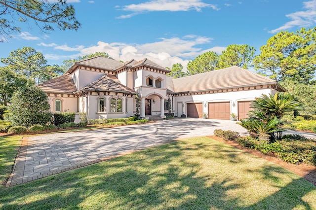 mediterranean / spanish-style home featuring a front yard and a garage