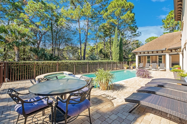 view of swimming pool featuring a patio area and an in ground hot tub