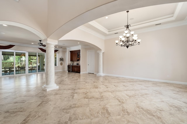 unfurnished living room featuring ceiling fan with notable chandelier, a raised ceiling, ornamental molding, and decorative columns