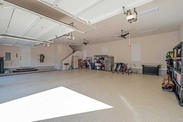 garage featuring electric panel, ceiling fan, and a garage door opener