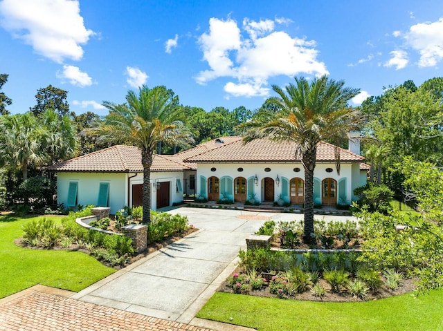 mediterranean / spanish home with a front lawn and a garage