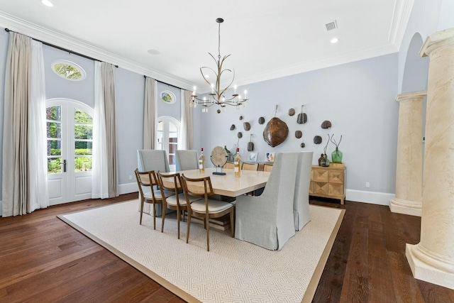 dining area featuring a notable chandelier, crown molding, ornate columns, and dark wood-type flooring