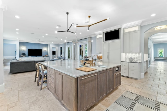 kitchen featuring crown molding, white cabinetry, sink, and a spacious island