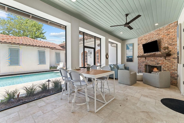 exterior space featuring ceiling fan, a swimming pool, wooden ceiling, and an outdoor brick fireplace