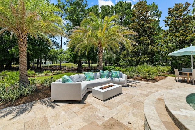 view of patio with an outdoor living space with a fire pit