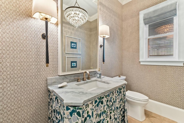 bathroom featuring tile patterned floors, ornamental molding, vanity, a notable chandelier, and toilet