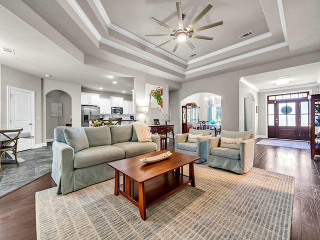 living room featuring hardwood / wood-style flooring, a raised ceiling, ceiling fan, and crown molding