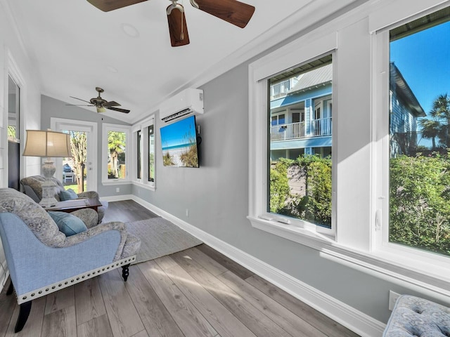 living area with lofted ceiling, ceiling fan, hardwood / wood-style flooring, and a wall mounted AC