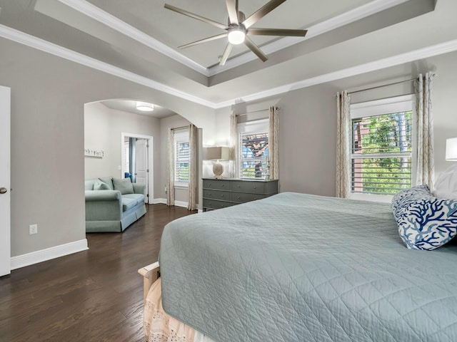 bedroom featuring a raised ceiling, ceiling fan, crown molding, and dark wood-type flooring