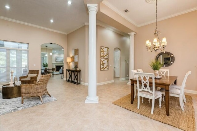 dining room featuring crown molding, decorative columns, a fireplace, and arched walkways