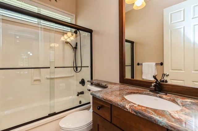 bathroom featuring vanity, toilet, and enclosed tub / shower combo