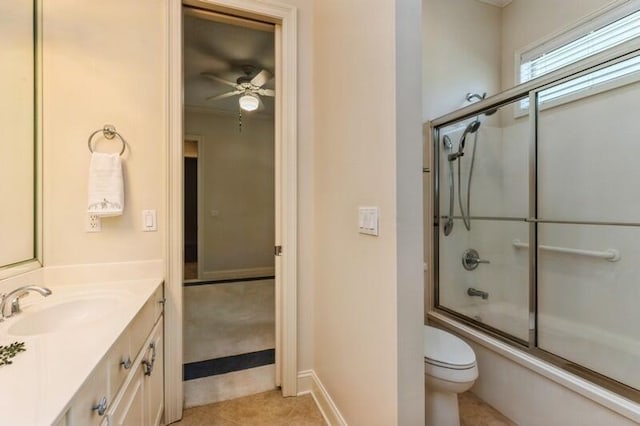 bathroom featuring vanity, a ceiling fan, enclosed tub / shower combo, tile patterned flooring, and toilet