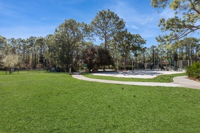 view of home's community featuring playground community and a lawn