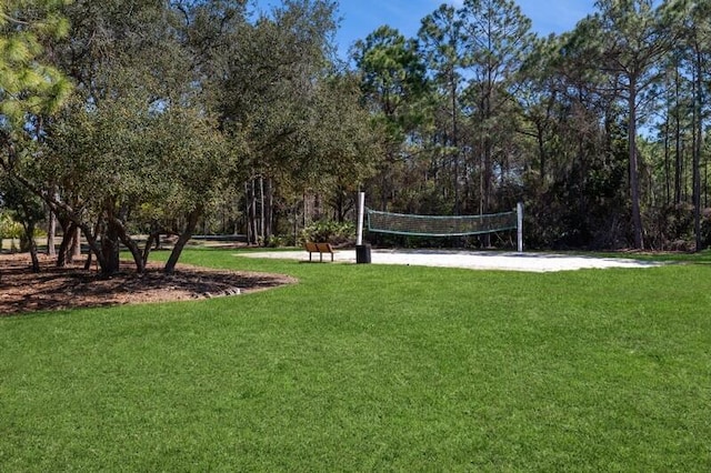 view of home's community featuring volleyball court and a lawn