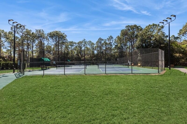 view of sport court featuring a lawn and fence