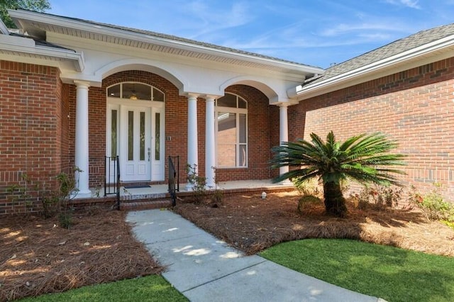 property entrance featuring brick siding and covered porch